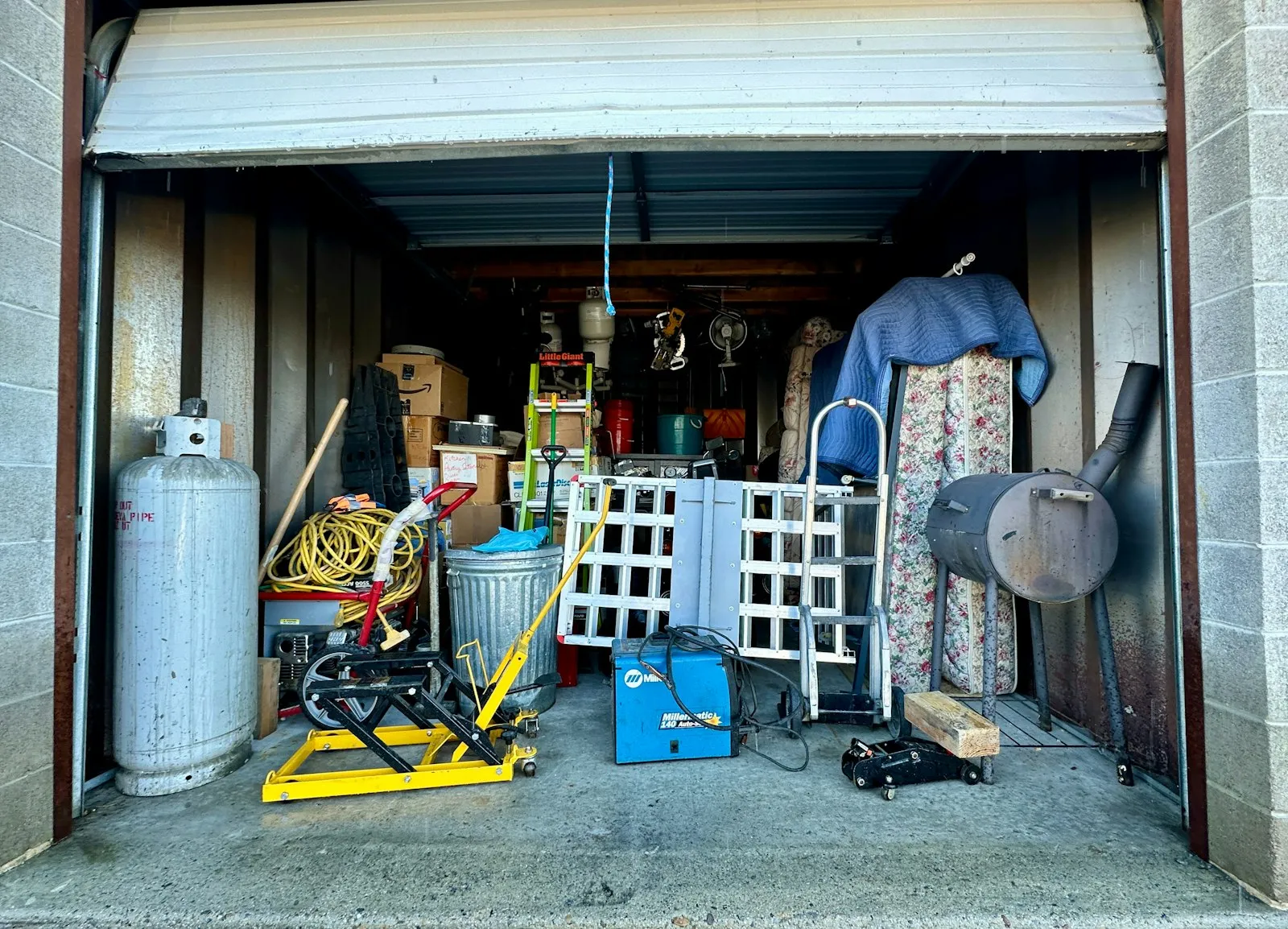 A garage packed with clutter and tools, ready to be cleared out.